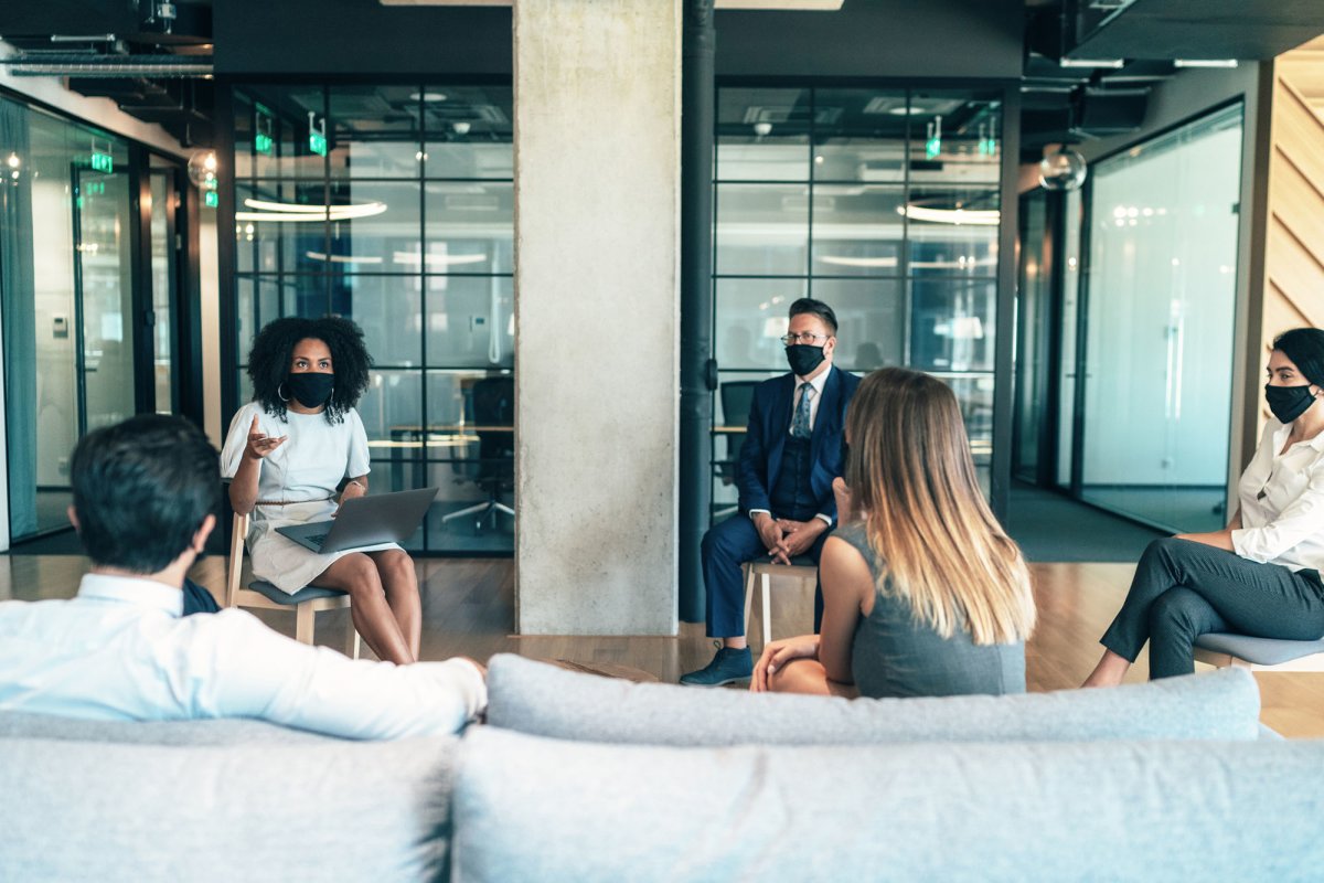 people gathered around talking in an office setting